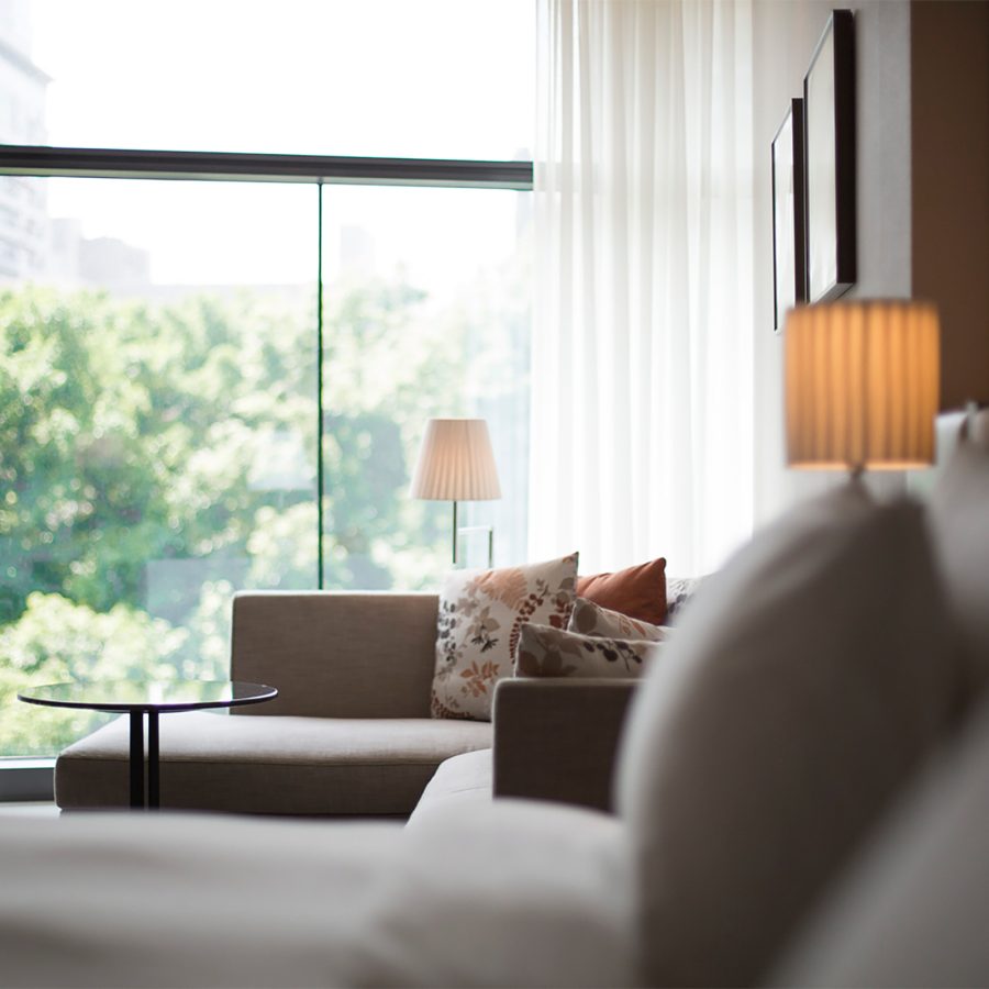 Tranquil view of the bed and greenery through the window at a Eslite Hotel room.