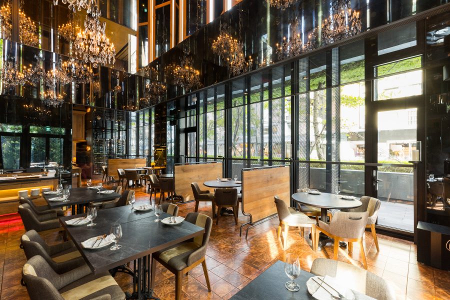 A dining room at Hotel Proverbs with warm yellow chandeliers.