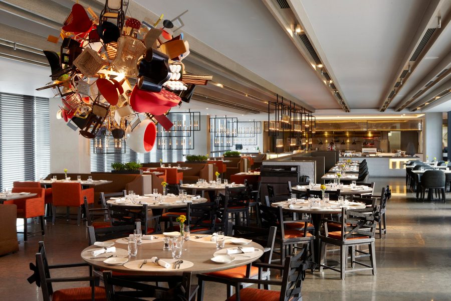 Eclectic chair chandelier hangs over the dining room at a Humble House restaurant. 