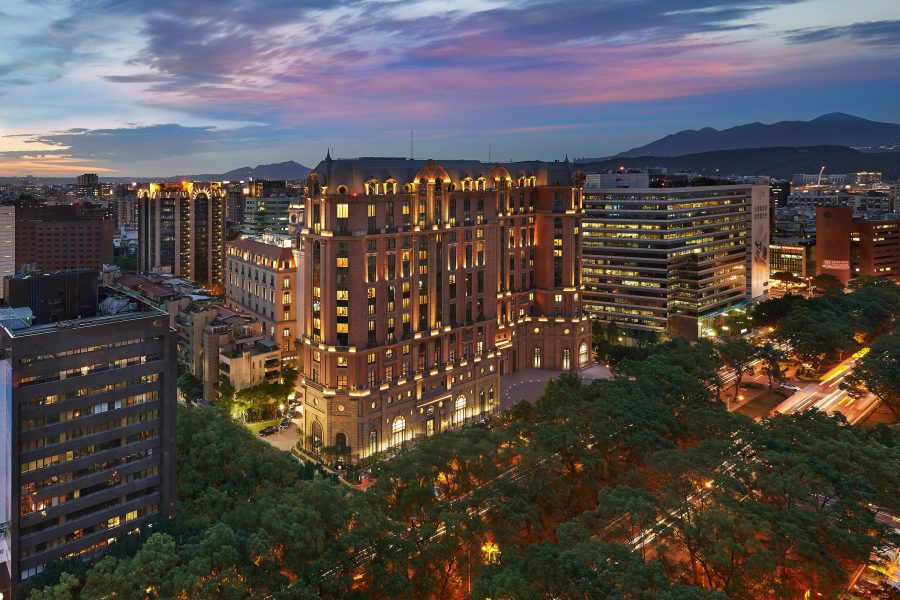 View of the Mandarin Oriental, Taipei at night surrounding by buildings.