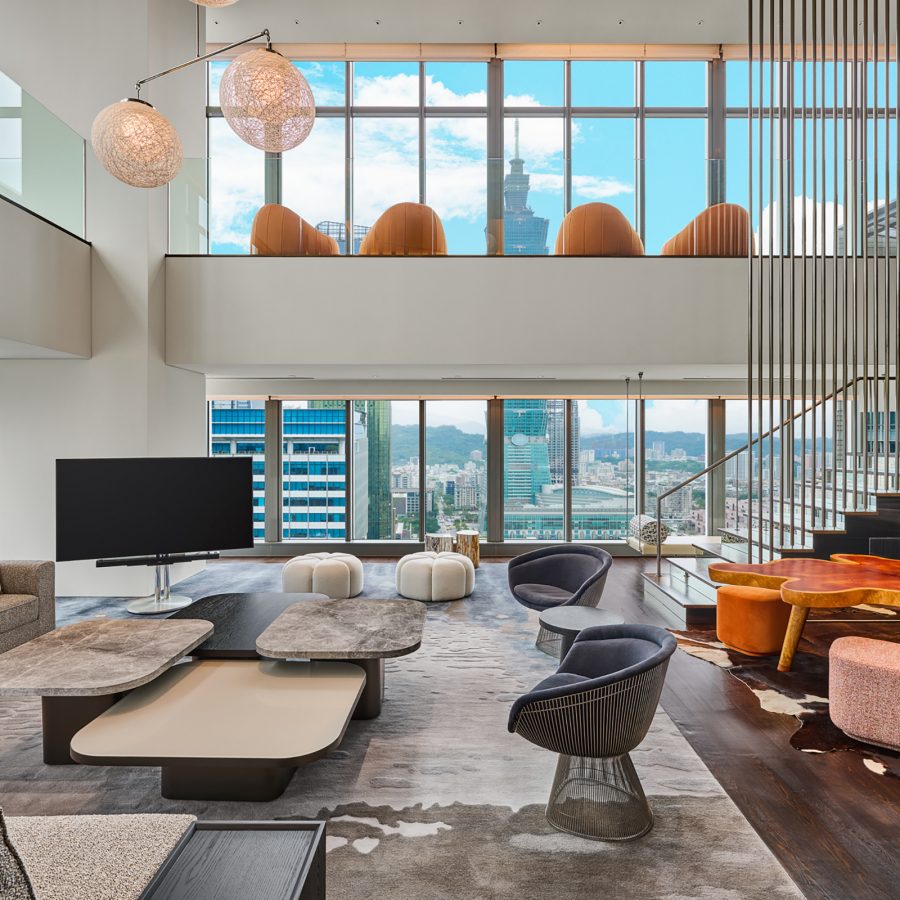View of a two-storey lounge at the W Taipei with the skyline in the background.