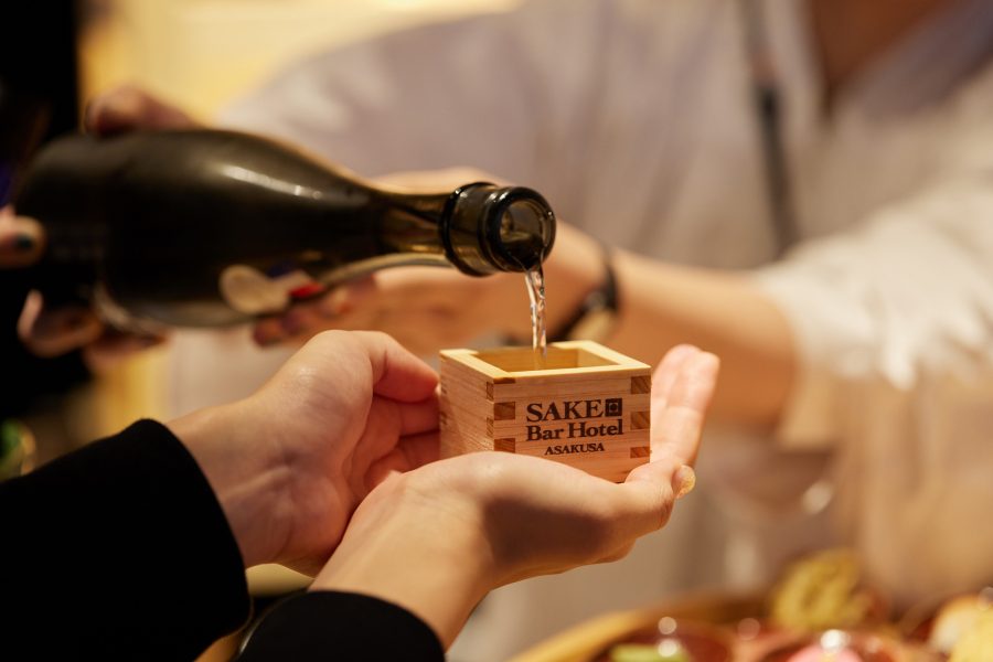 Sake being poured into a traditional wooden sake cup at the Sake Bar Hotel Tokyo.