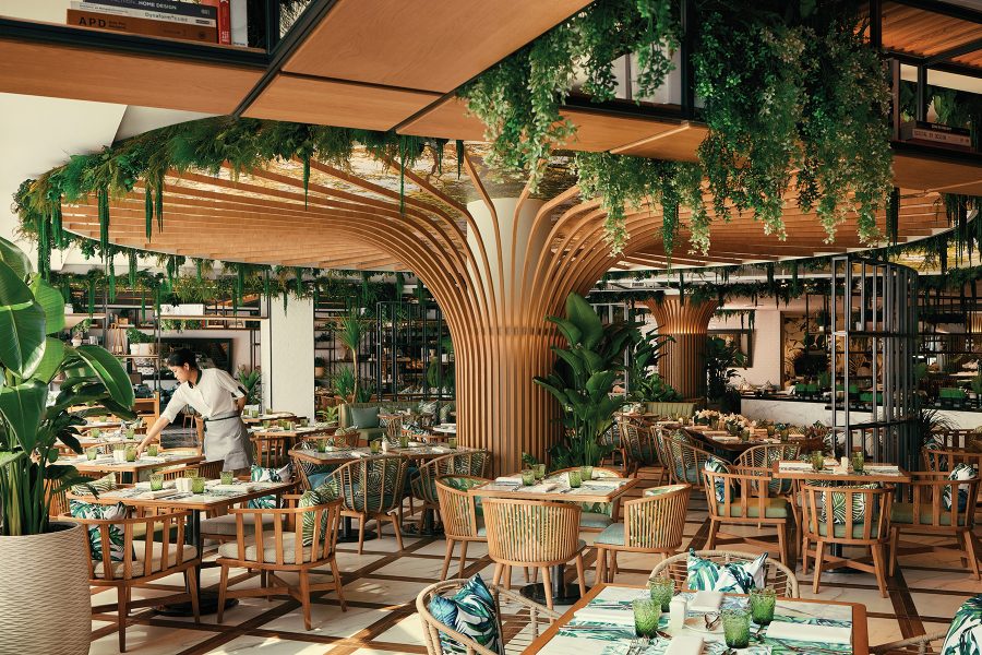 At nature-inspired restaurant Embu, a large tree-shaped column covered in hanging foliage stands in the centre of the room, surrounded by wooden tables and chairs. Plants and foliage are placed throughout the restaurant.
