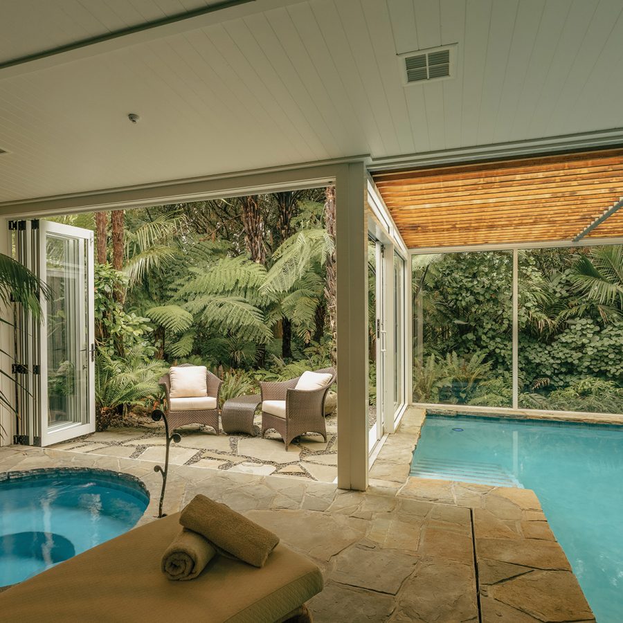 Hydrotherapy facilities like two pools and an outdoor lounging area next to a forest at The Spa at Rosewood Kauri Cliff, which offers couple treatments for guests.