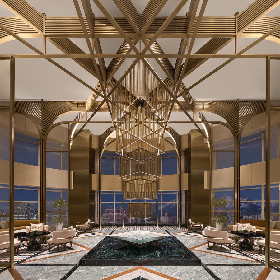 The lobby of Conrad Urumqi, with gold-toned arches and a marble floor with geometric patterns. 