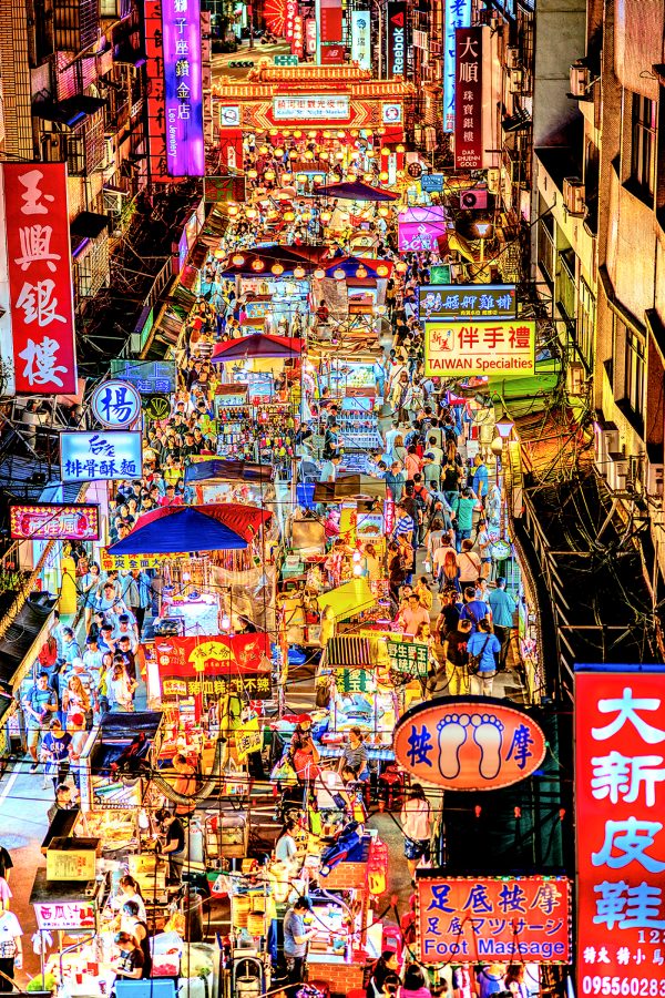 Raohe Night Market seen from above bustles with visitors milling about crowded stalls selling street food.