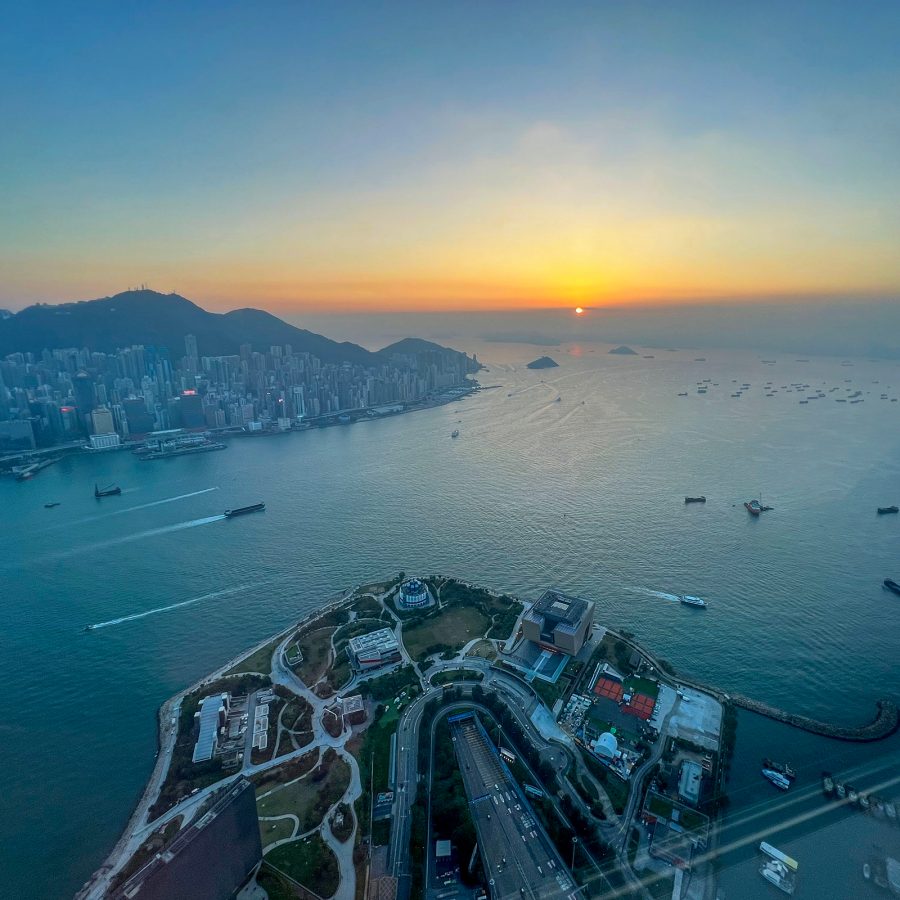 A bird’s eye view of West Kowloon Cultural District and Victoria Harbour at sunset in Hong Kong.