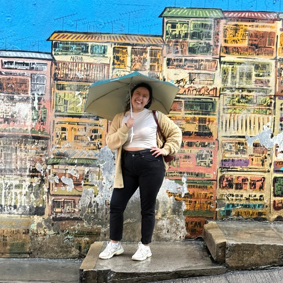 The writer posing in front of Alex Croft’s famous tong lau mural in Hong Kong.