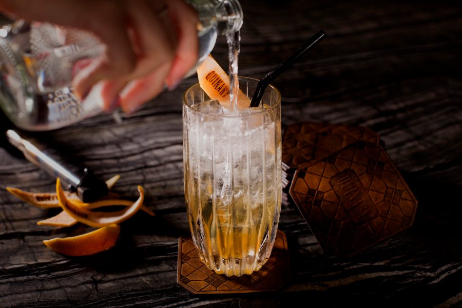 Person pouring an amber coloured cocktail at Quinary.