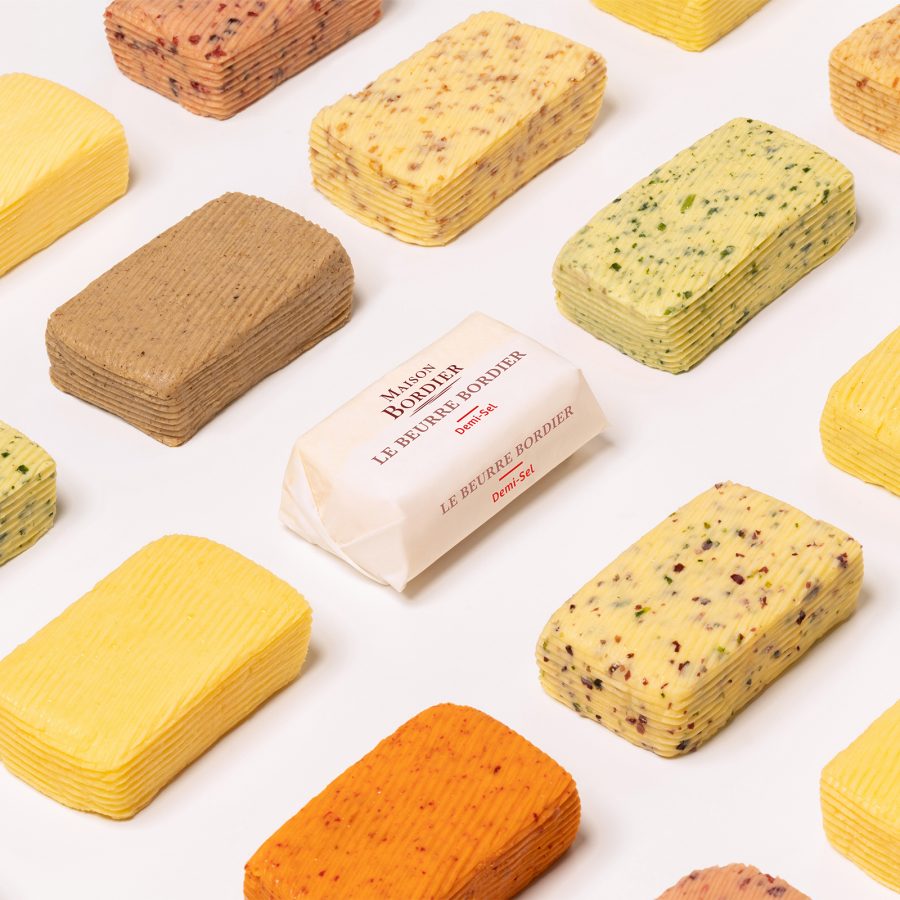Multiple slabs of Le Beurre Bordier butter of all flavours against a white backdrop.