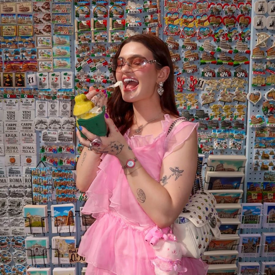 Content creator Samantha Todd eating gelato against a backdrop of souvenir magnets.