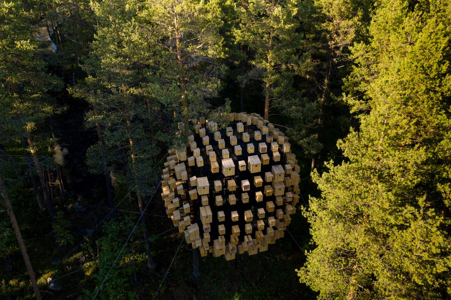 A bird’s eye view of the exterior of the Biosphere capsule, surrounded by green trees at Tree Hotel in Sweden.