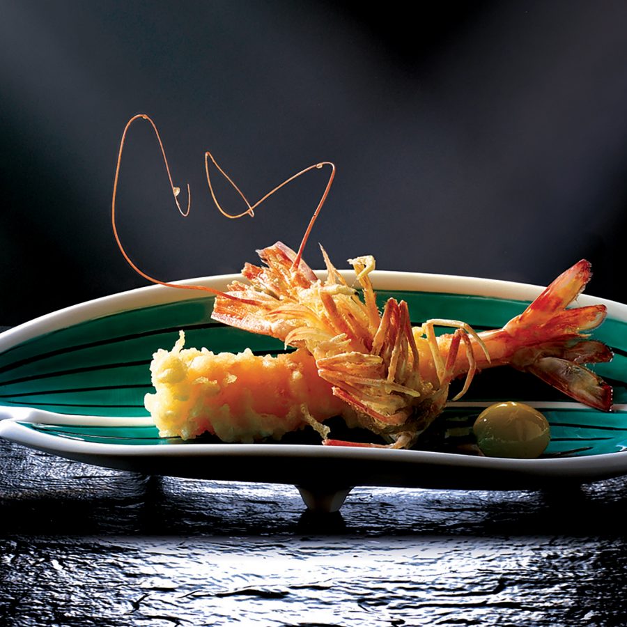 A closeup of a single deep fried tempura prawn and olive on a green plate, served at Shikigiku Japanese Restaurant at The Royal Garden