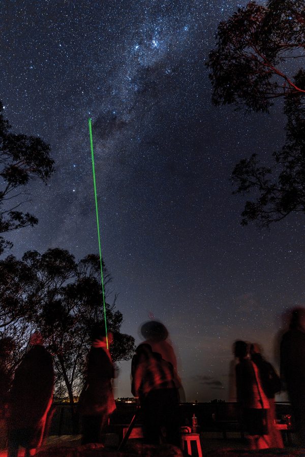 A group of people stargazing at night at the Blue Mountains National Park in Australia.