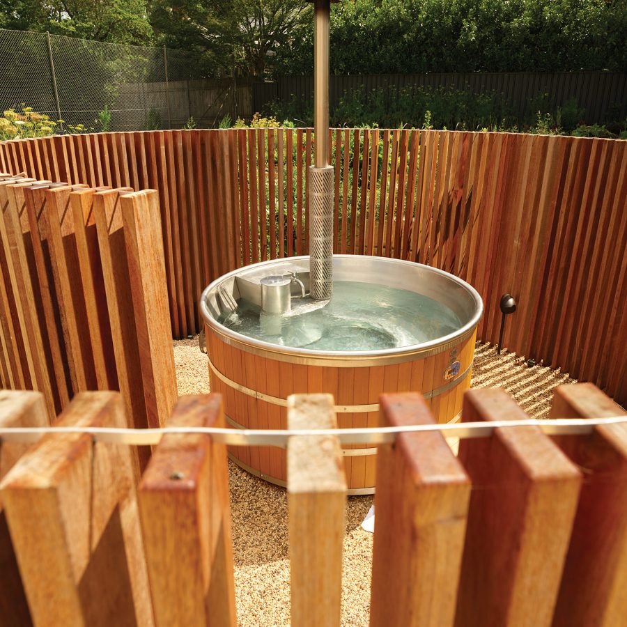 A view of an outdoor hot tub concealed within a wooden structure at Kyah Hotel nearby Blue Mountains National Park in Australia.