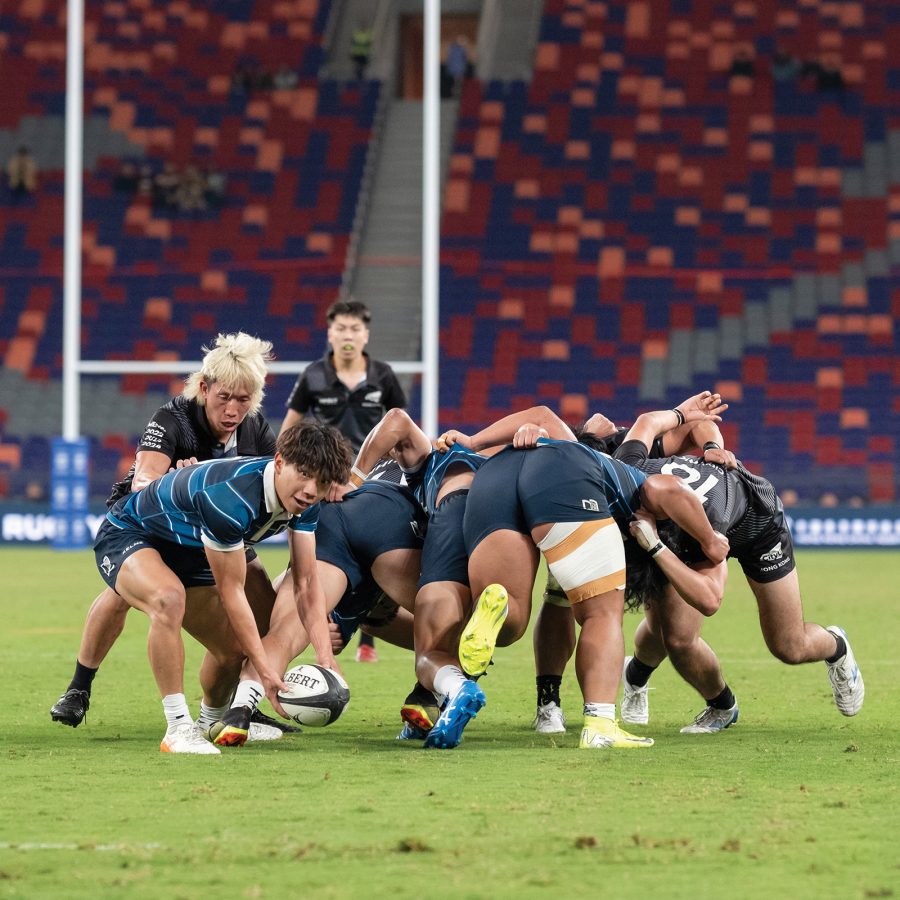 A group of rugby players huddled on the field at the Kai Tak Stadium at Kai Tak Sports Park in Hong Kong.