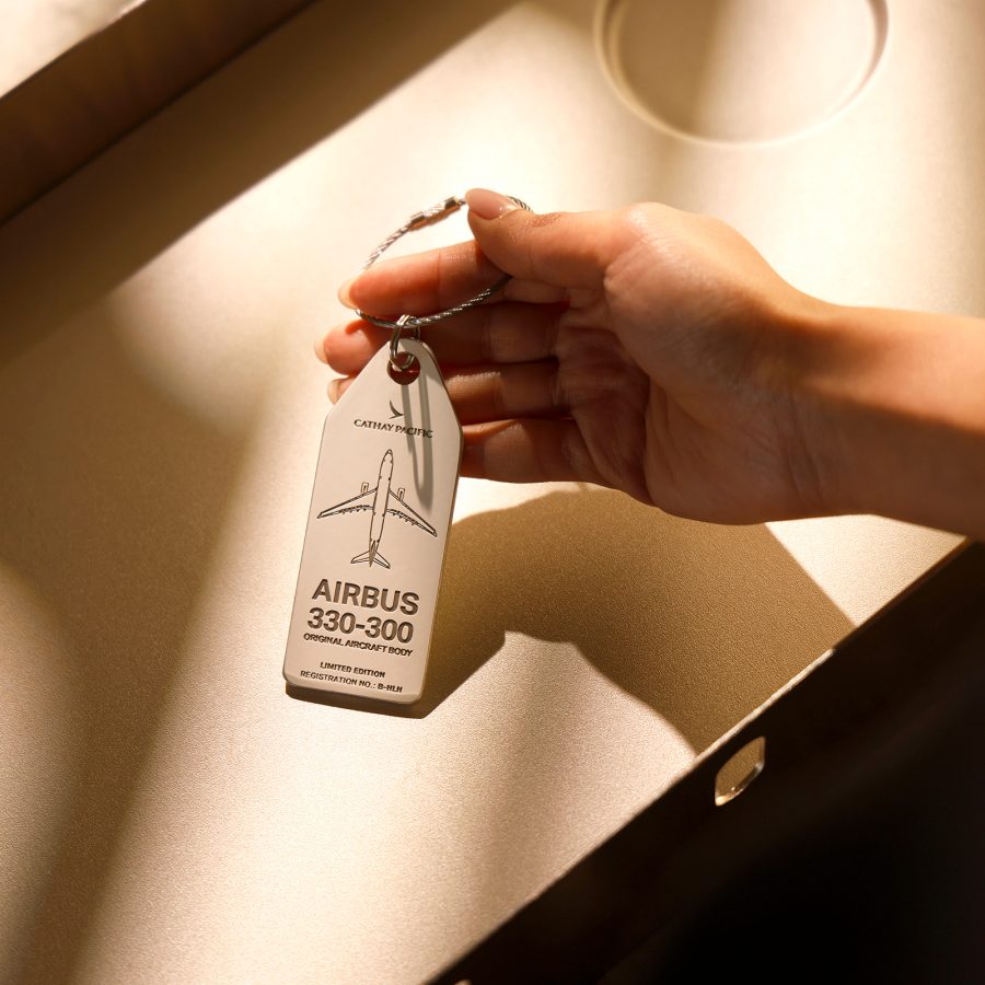 A person lifts up an aviation tag crafted from an Airbus 330-300 aircraft retired from Cathay’s fleet in 2020. 