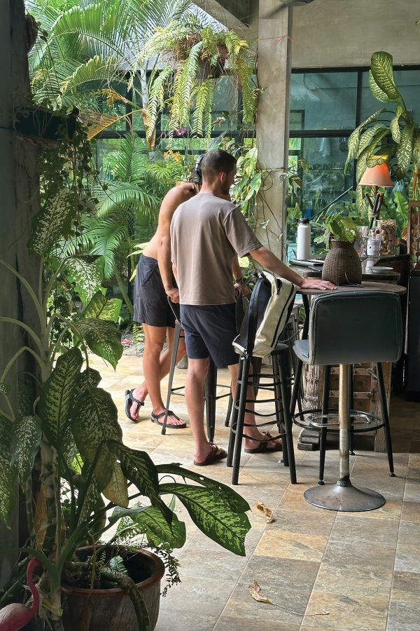 Two men standing on a leafy porch at Elsie Evans Art Retreat in Ryong, Thailand