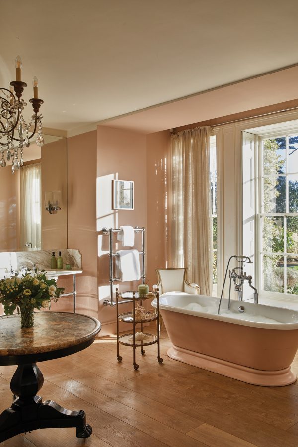 A guestroom bathroom with garden view through a large window during a Your Creative Escapes art holiday