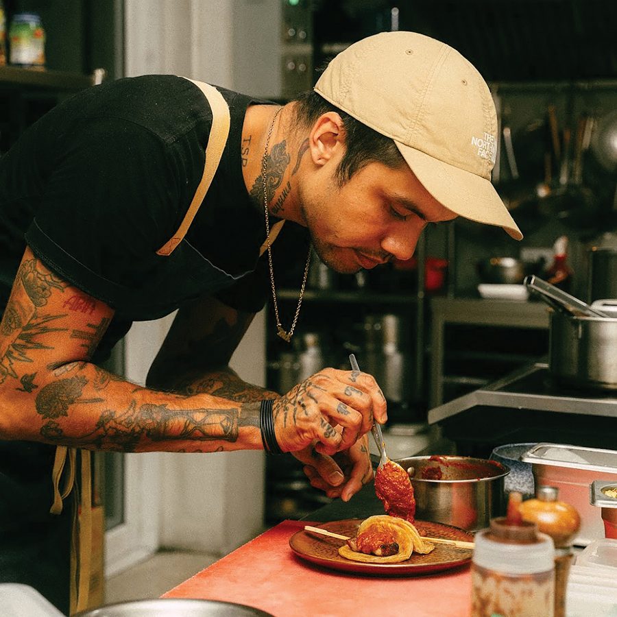 Chef Dylan Eitharong plating a dish at Haawm