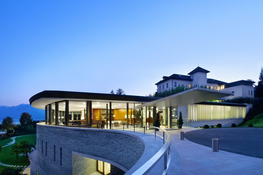 An exterior view of Clinique La Prairie in Montreux after sunset.
