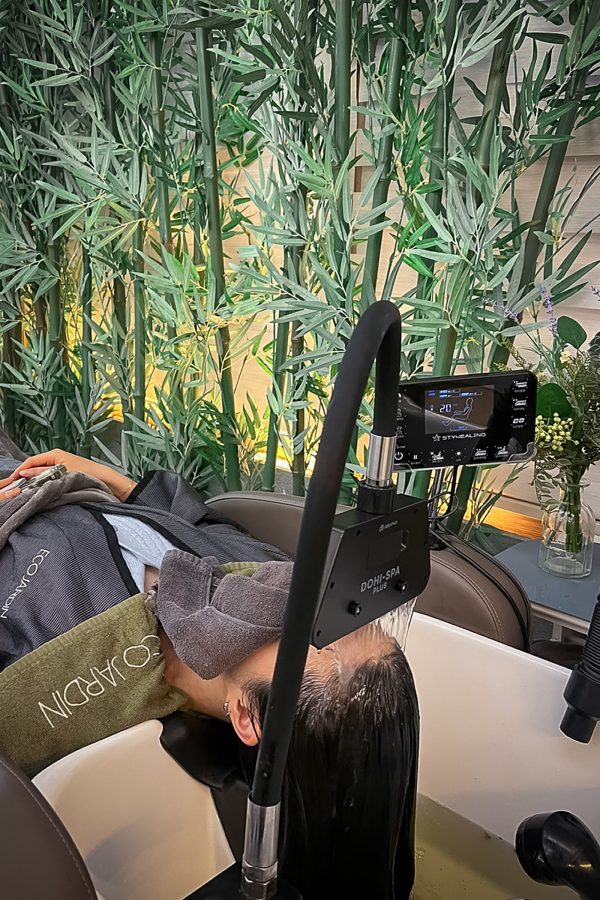 A woman lying down for a hair spa treatment. 