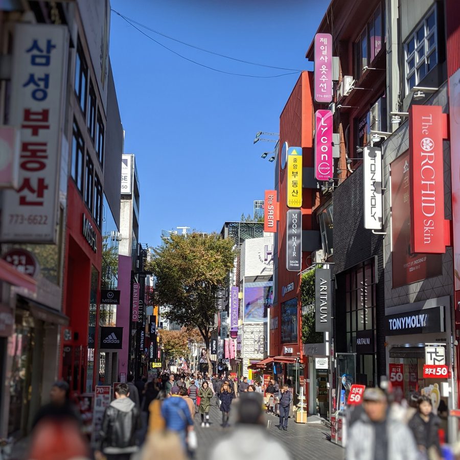 People walking on a street with many shops in Myeongdong.