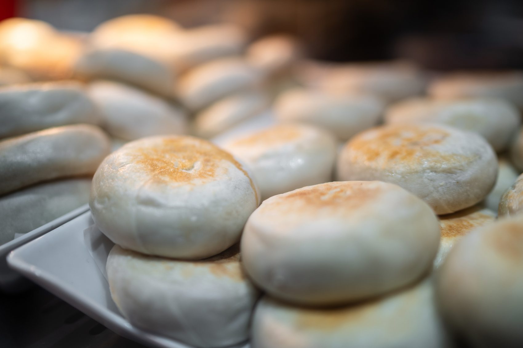 A closeup of platters of mending roubing Beijing-style meat pies.