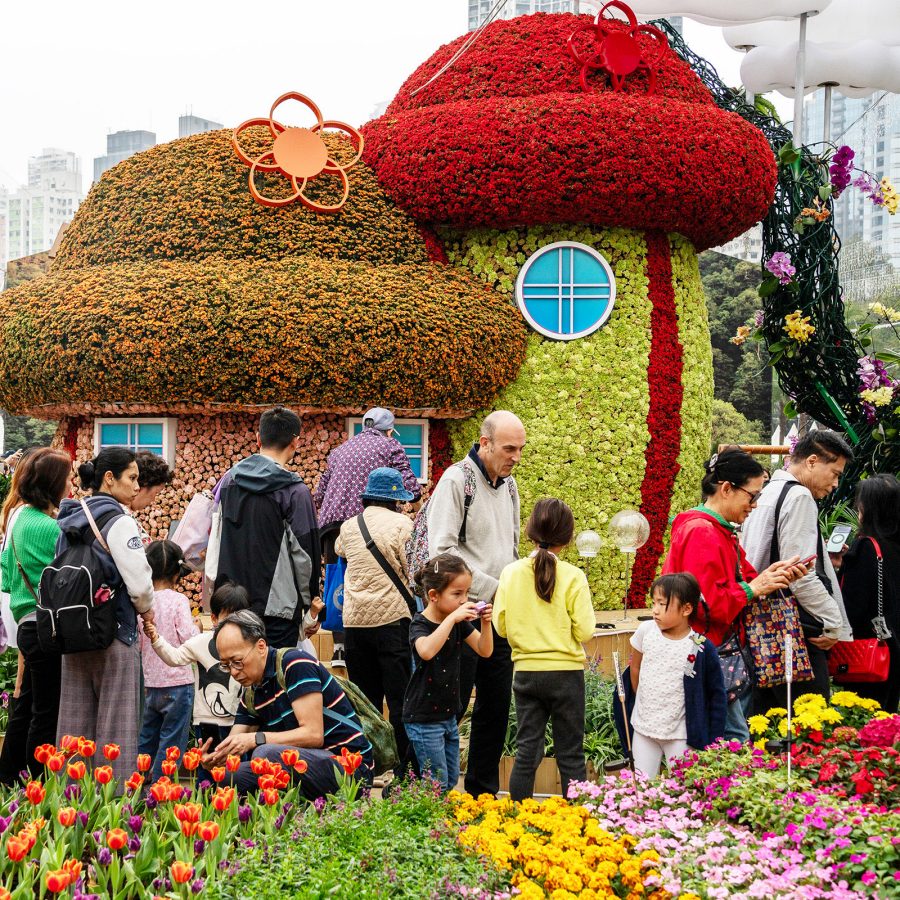 People pass by a floral installation of mushroom houses at the Hong Kong Flower Show