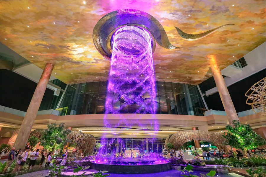 An indoor waterfall illuminated purple in the Alangkarn zone at IconSiam, Bangkok. 