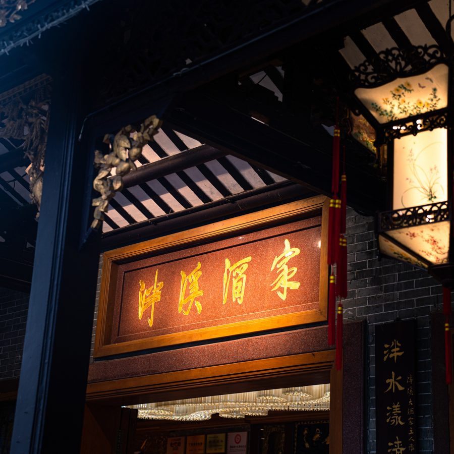 A four word Chinese slogan hangs across a traditional Chinese structure at Panxi Restaurant.