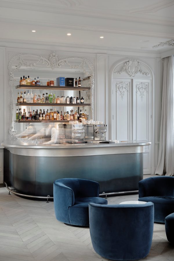 Bartenders move at speed behind the blue bar counter at the Château de Mirwart.