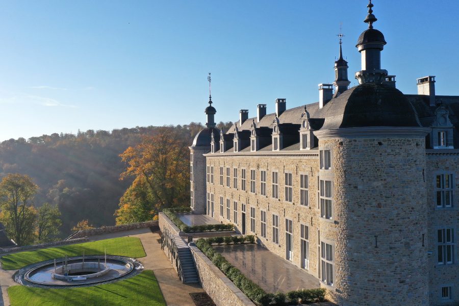 Exterior view of a castle hotel in Belgium on a blue, sunny day.
