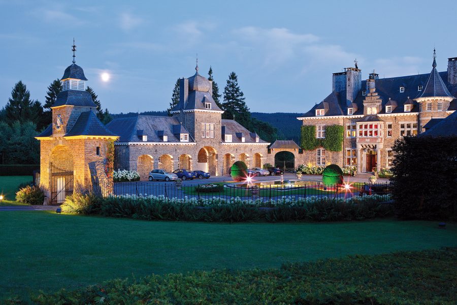 Exterior view of Manoir de Lébioles at night in Belgium.