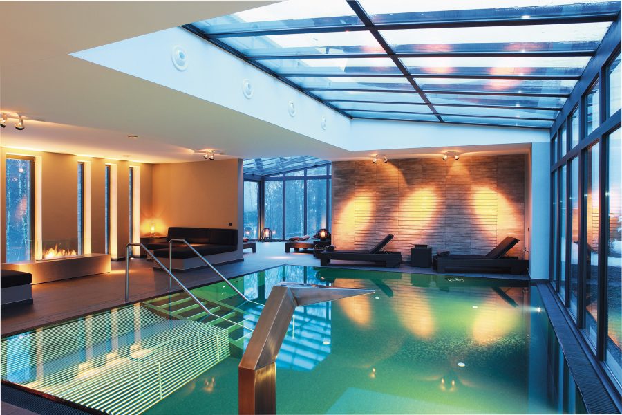 An indoor swimming pool with a glass roof at the Manoir de Lébioles in Belgium. 
