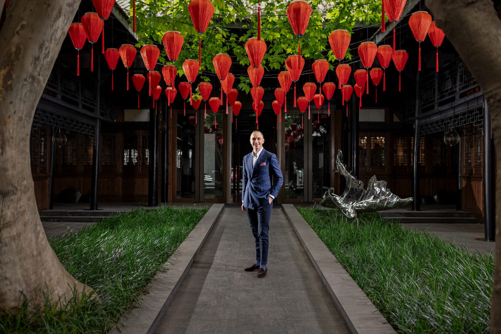 Christian Kronast, GM of The Temple House in Chengdu, stands in the courtyard of the hotel underneath a display of red lanterns.