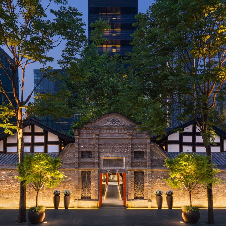The front entrance of The Temple House in Chengdu illuminated at night. 