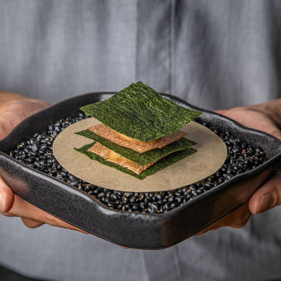 Green and pale brown dish served at Nen Light on a dark plate. 