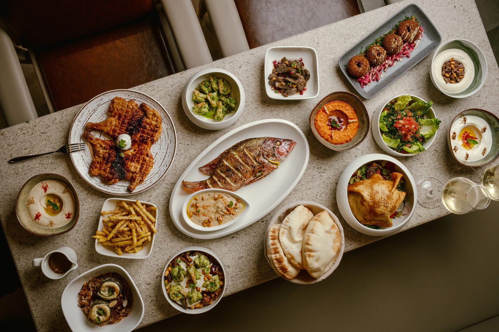 A flatlay of various halal dishes laid out on a dining table in family style at Cafe Kool at Kowloon Shangri-La, hong Kong.
