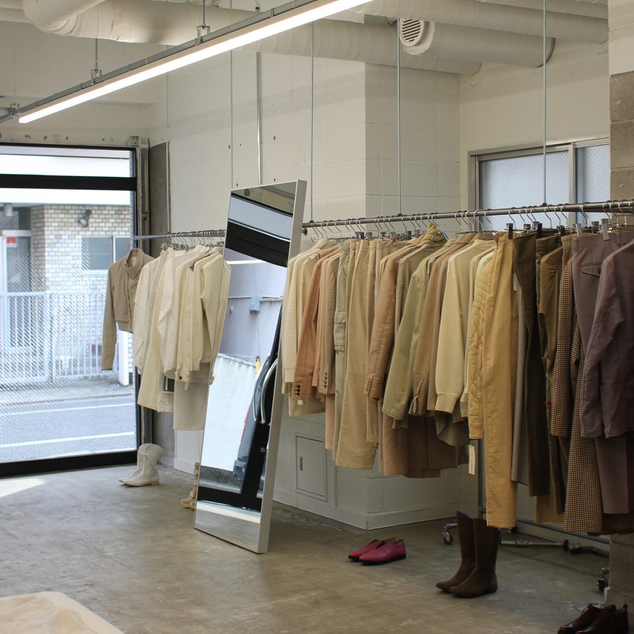 A rack of clothing and a full-length mirror at Kakko, Tokyo, in the daytime. 