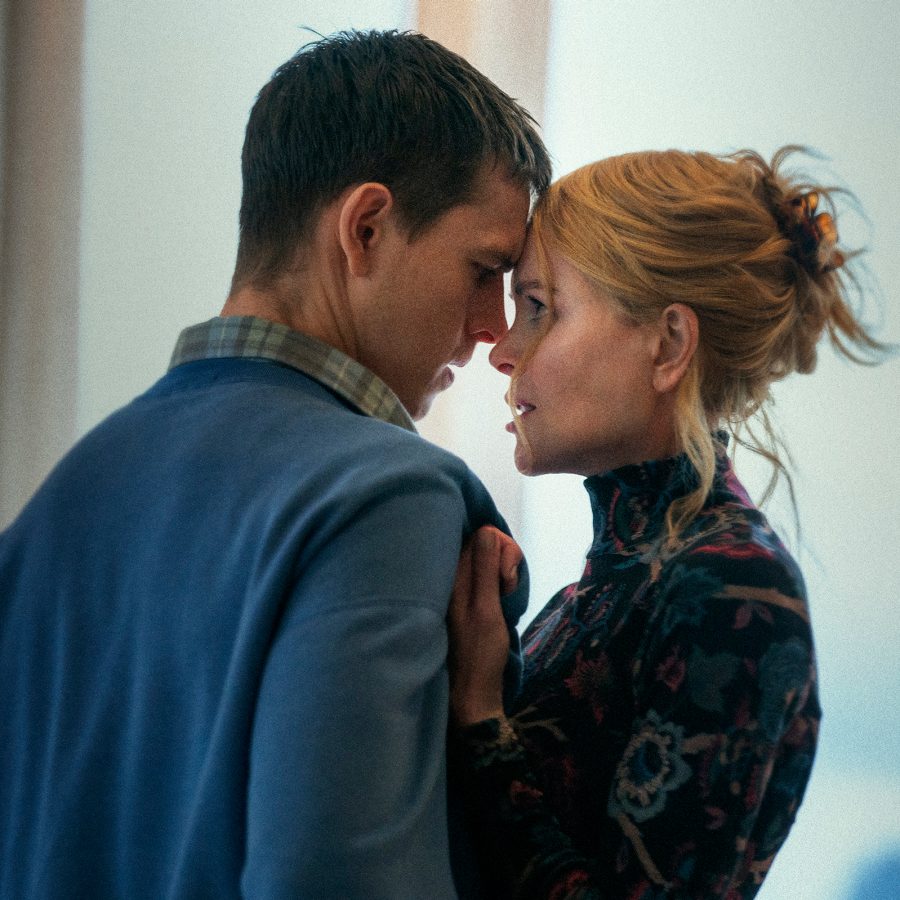 This scene from Babygirl shows a young man, Samuel (played by Harris Dickinson) and older woman, Romy (played by Nicole Kidman) standing close to one another and looking intensely in each other’s eyes. 