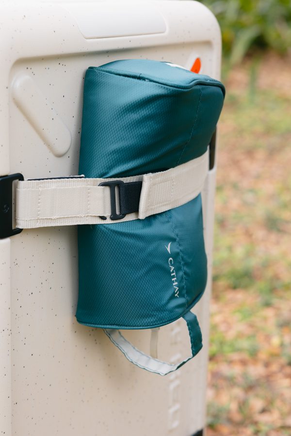 A Cathay pouch secured by the adjustable front straps of the ivory Samsonite TOIIS XP Trunk.