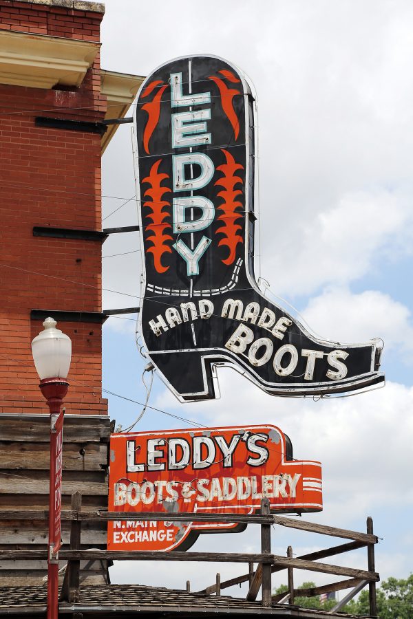 The neon signs of M.L. Leddy’s in the daytime. The larger sign is shaped like a cowboy boot.