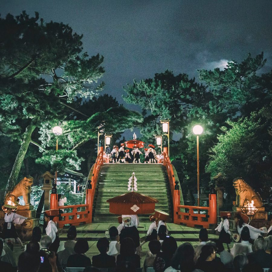 Crowds gather around the entrance of a temple in Osaka