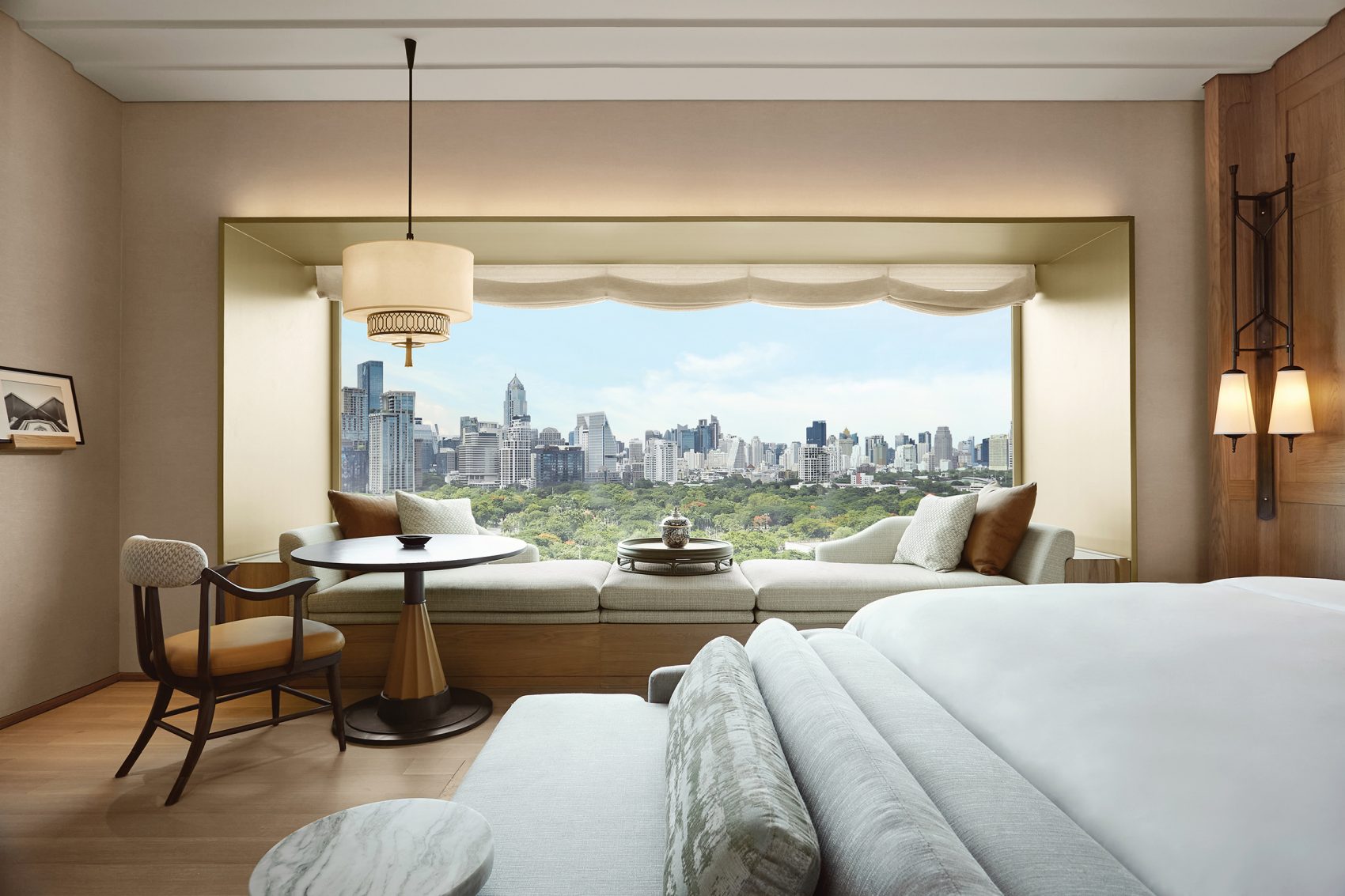 A guestroom in Dusit Thani Bangkok with a large window and city view.