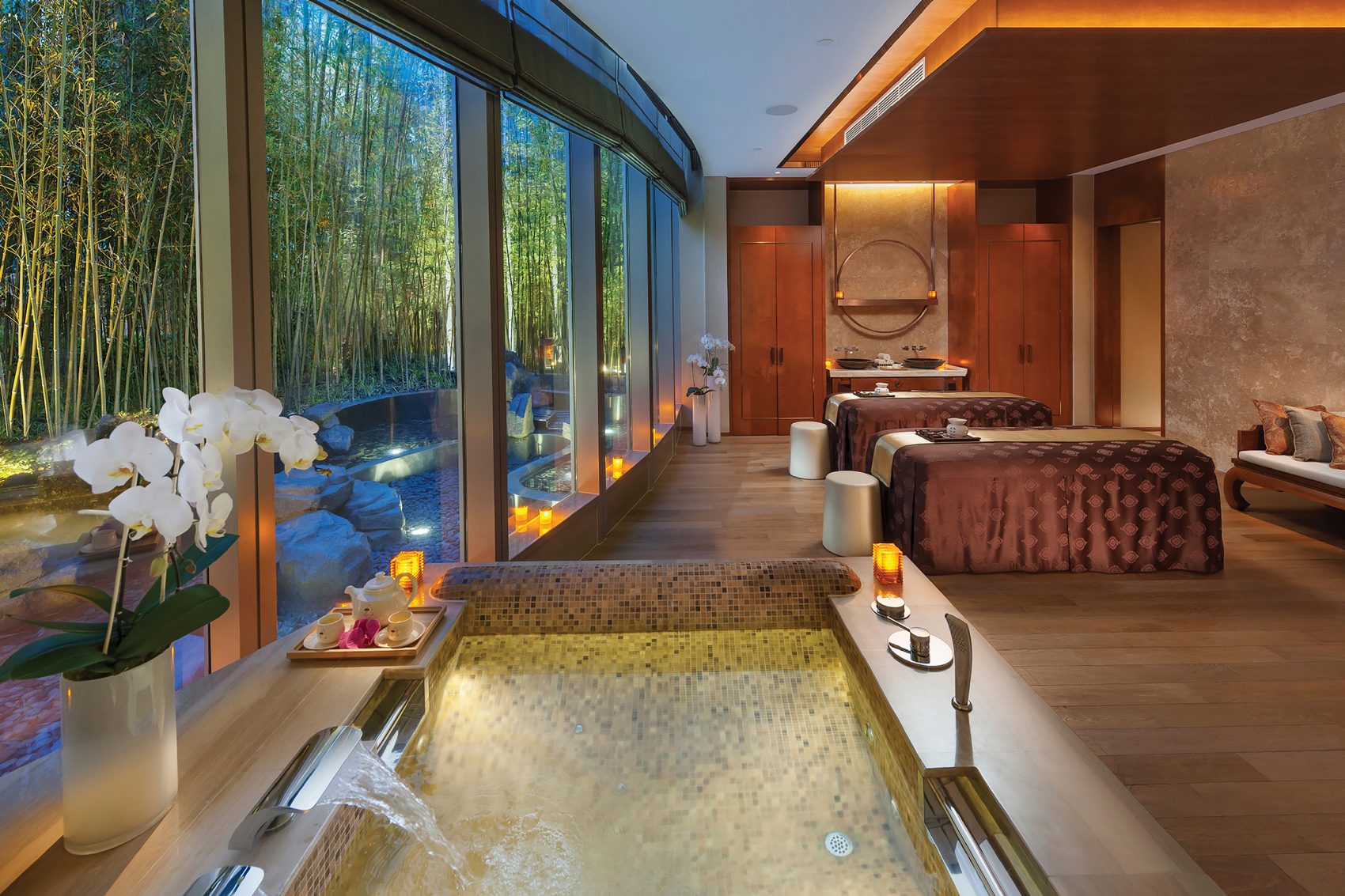 A spa treatment room in Mandarin Oriental Pudong, Shanghai with a hot tub and two massage beds.