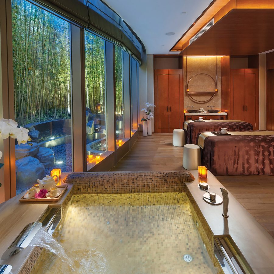 A spa treatment room in Mandarin Oriental Pudong, Shanghai with a hot tub and two massage beds.