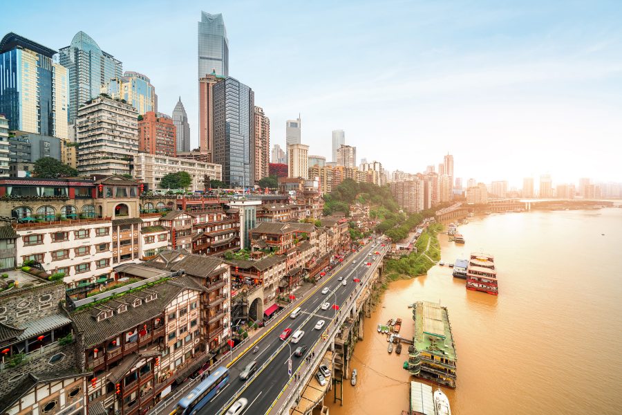 View of the river and low-rise buildings in Chongqing at sunset.