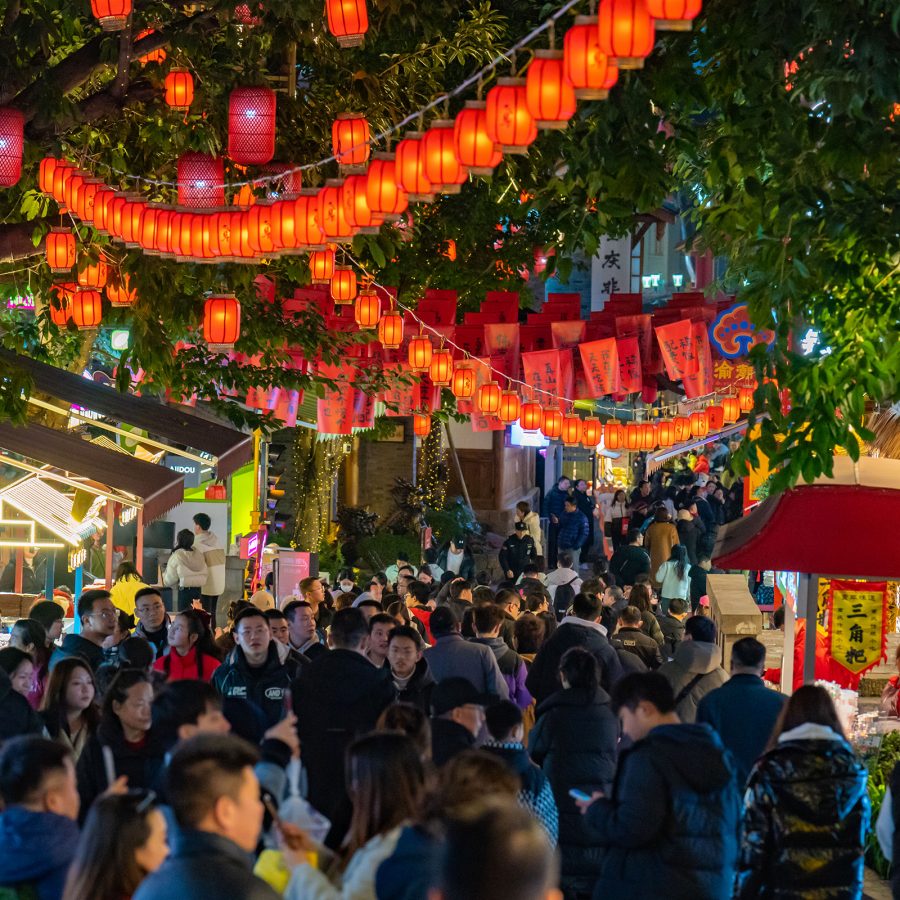 Lanterns hang from garlands strung between trees as crowds pass below in the Eighteen Steps area in Chongqing.