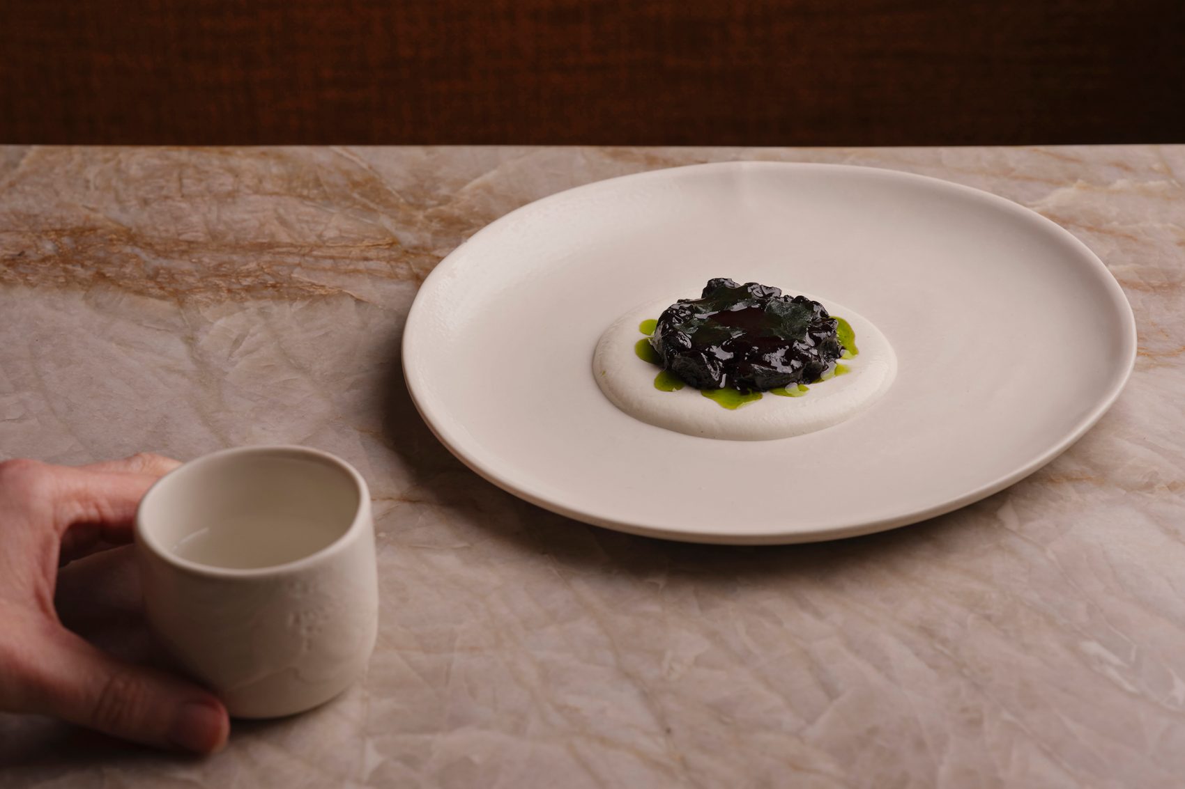 A dish is arranged artfully on a marbled counter at Plates London, the UK’s first vegan restaurant to earn a Michelin star. 
